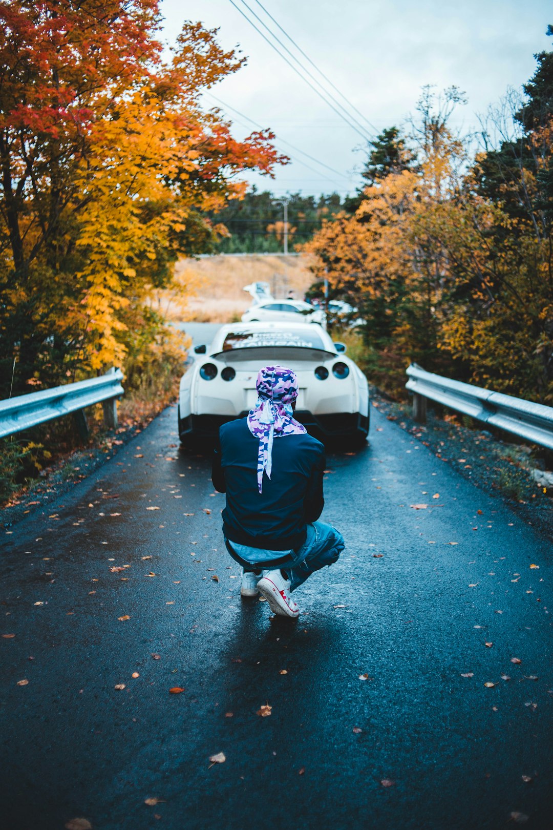 man taking photo of white vehicle at daytime