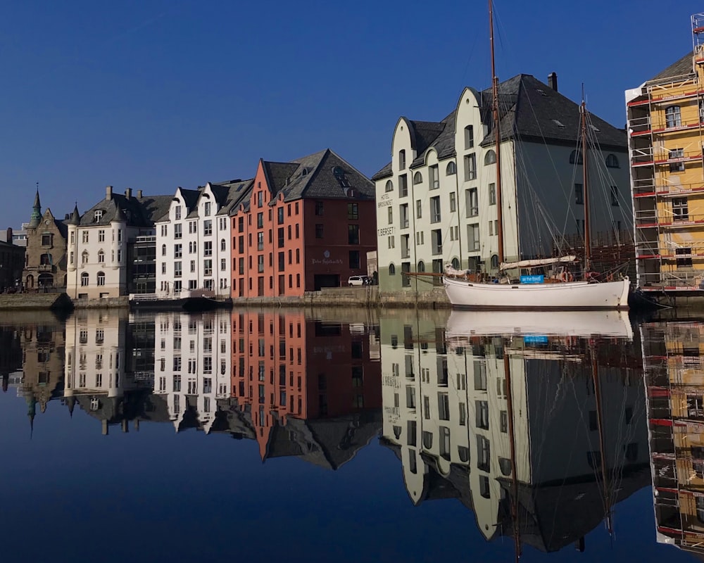 white and red painted buildings beside body of water