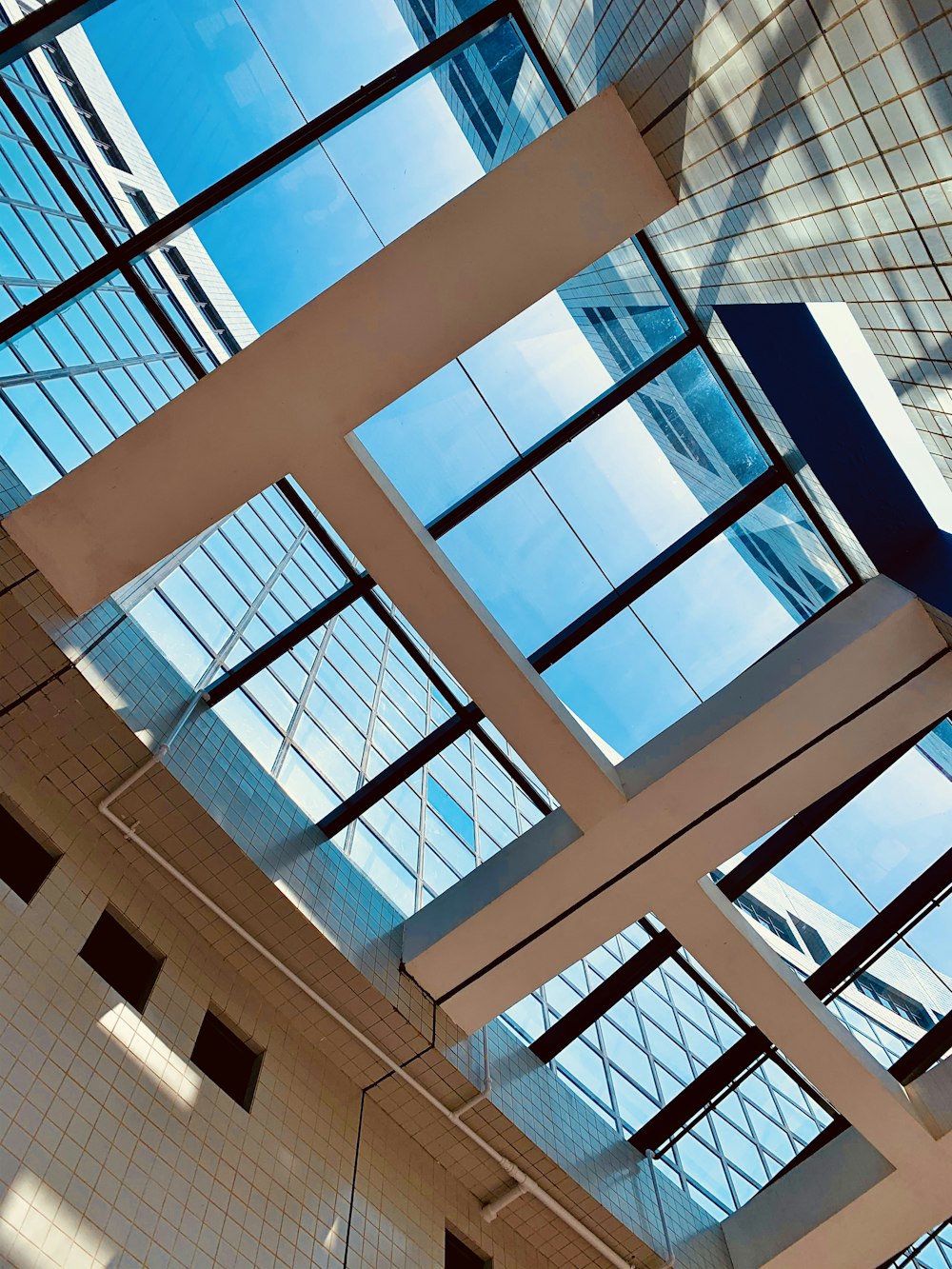 low-angle photography of blue glass walled building during daytime