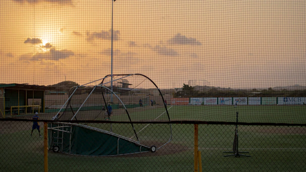 Young players practicing baseball drills together on a sunny community field.