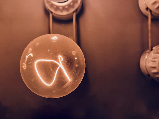 A bright LED bulb glowing warmly in a cozy room setting.