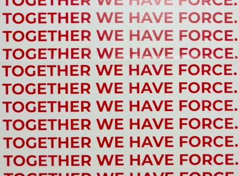 A repeated phrase in bold red capital letters on a white background says 'TOGETHER WE HAVE FORCE.' The words are aligned and occupy the entire visual space in rows.