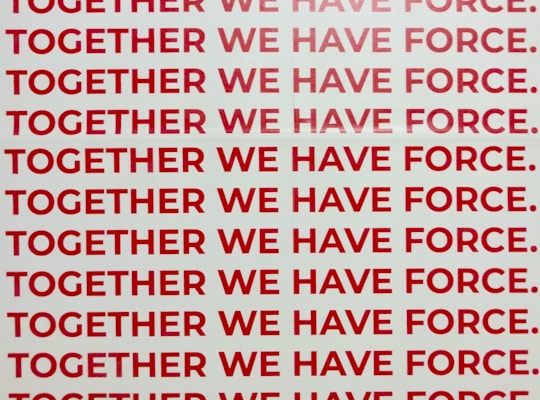 A repeated phrase in bold red capital letters on a white background says 'TOGETHER WE HAVE FORCE.' The words are aligned and occupy the entire visual space in rows.