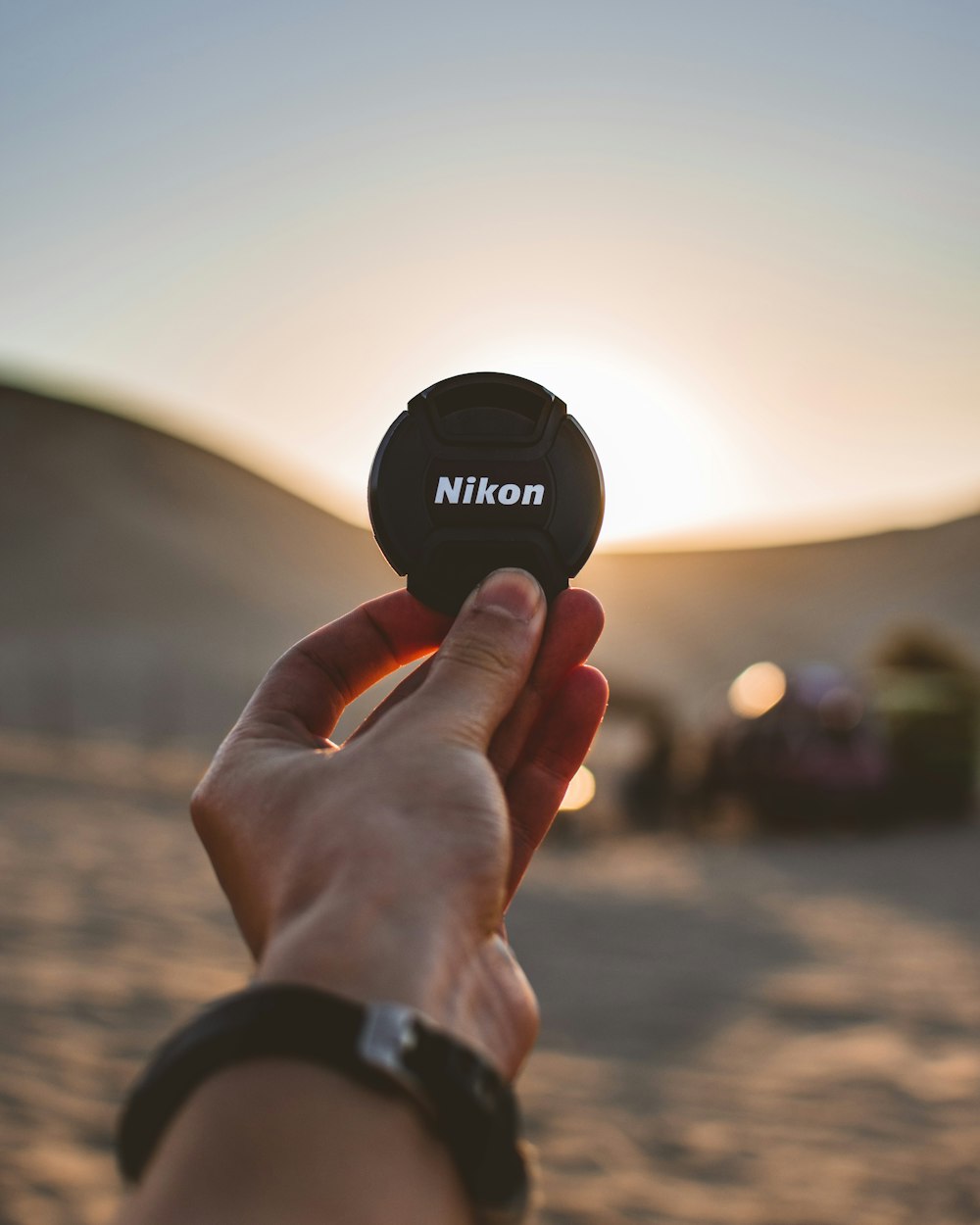 shallow focus photo of black Nikon camera lens cover