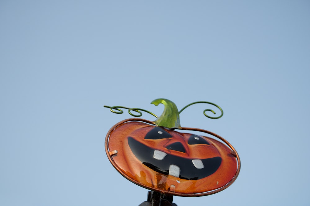 a pumpkin shaped decoration on top of a pole