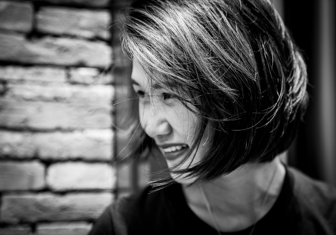 grayscale photography of woman wearing crew-neck t-shirt smiling