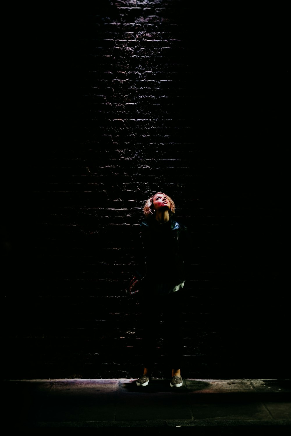 woman wearing blue jacket standing while looking up