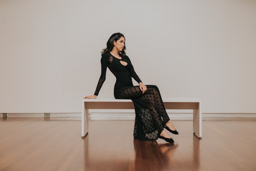 woman in black dress sitting on bench