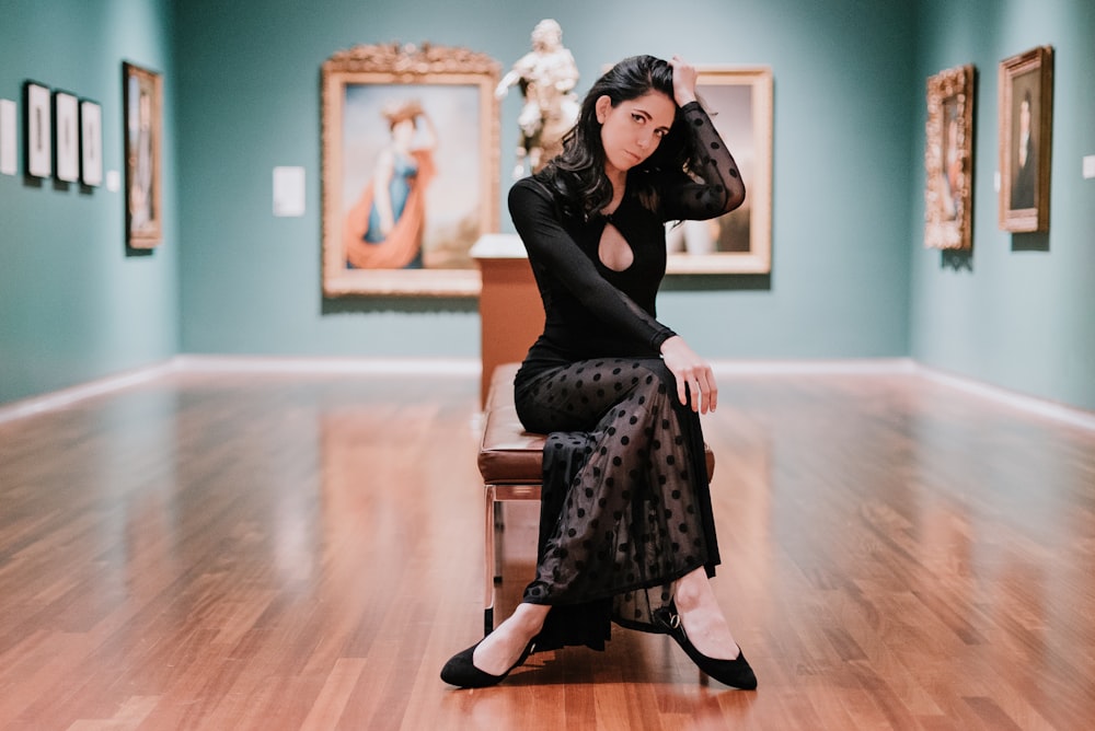 woman in black long-sleeved dress sitting on bench