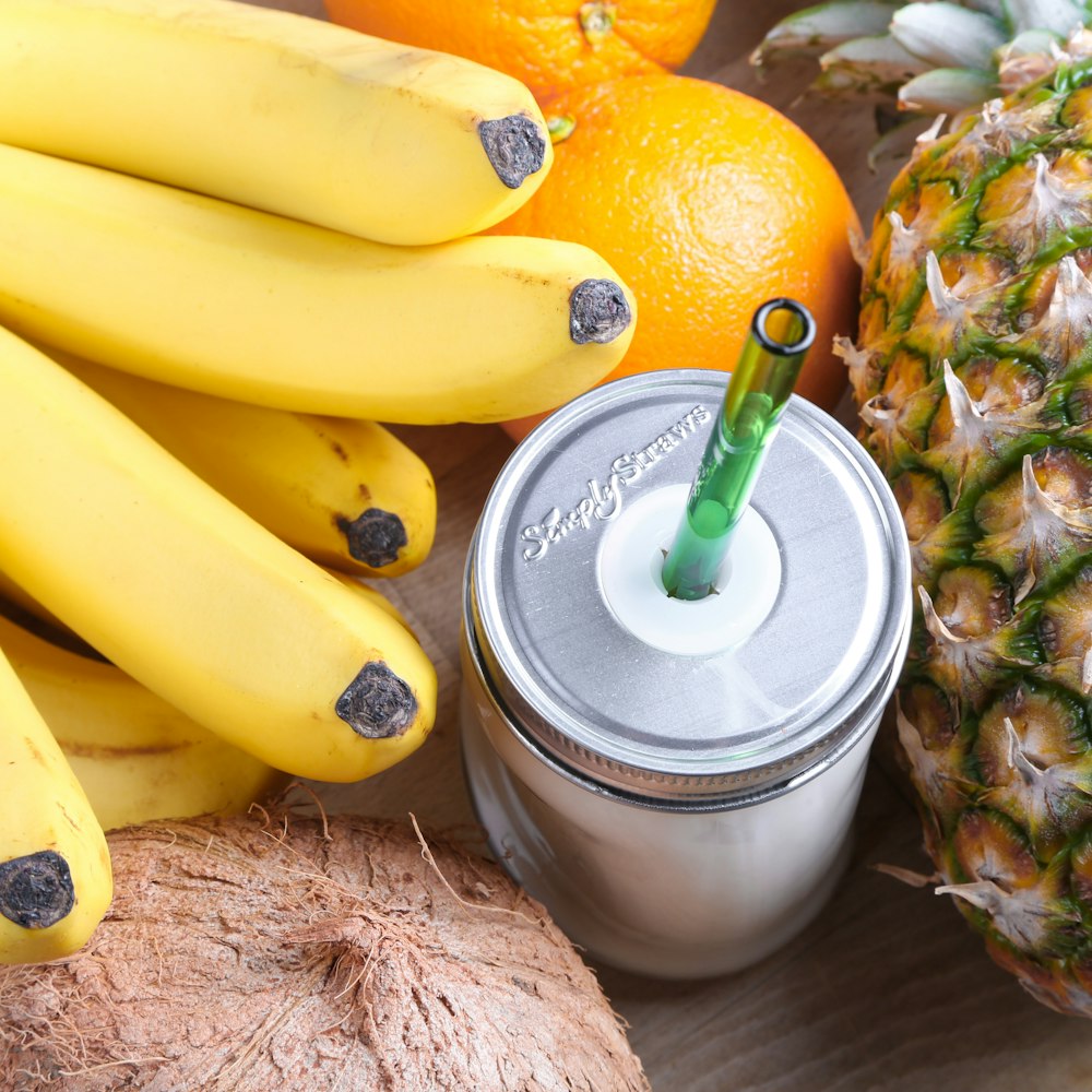 clear glass mason jar beside orange fruit and banana fruits