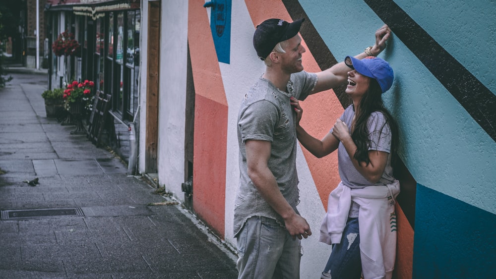 homme s’appuyant sur le mur devant la femme