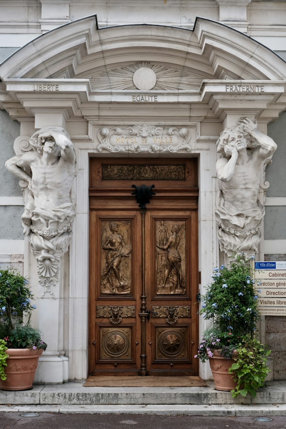 a large wooden door with statues on it