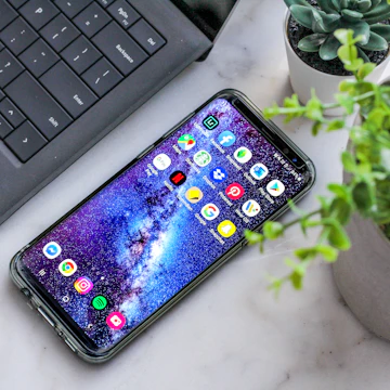 smartphone turned on beside laptop