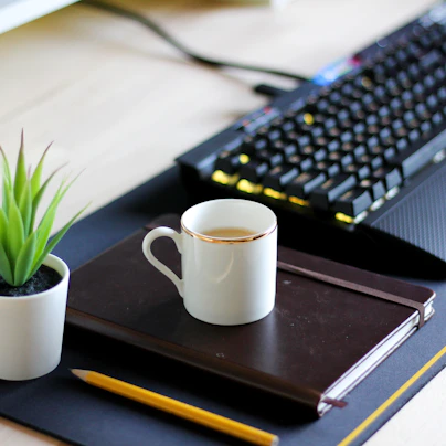 A tidy desk with a laptop, notebook, and a cup of coffee, symbolizing organized bookkeeping.