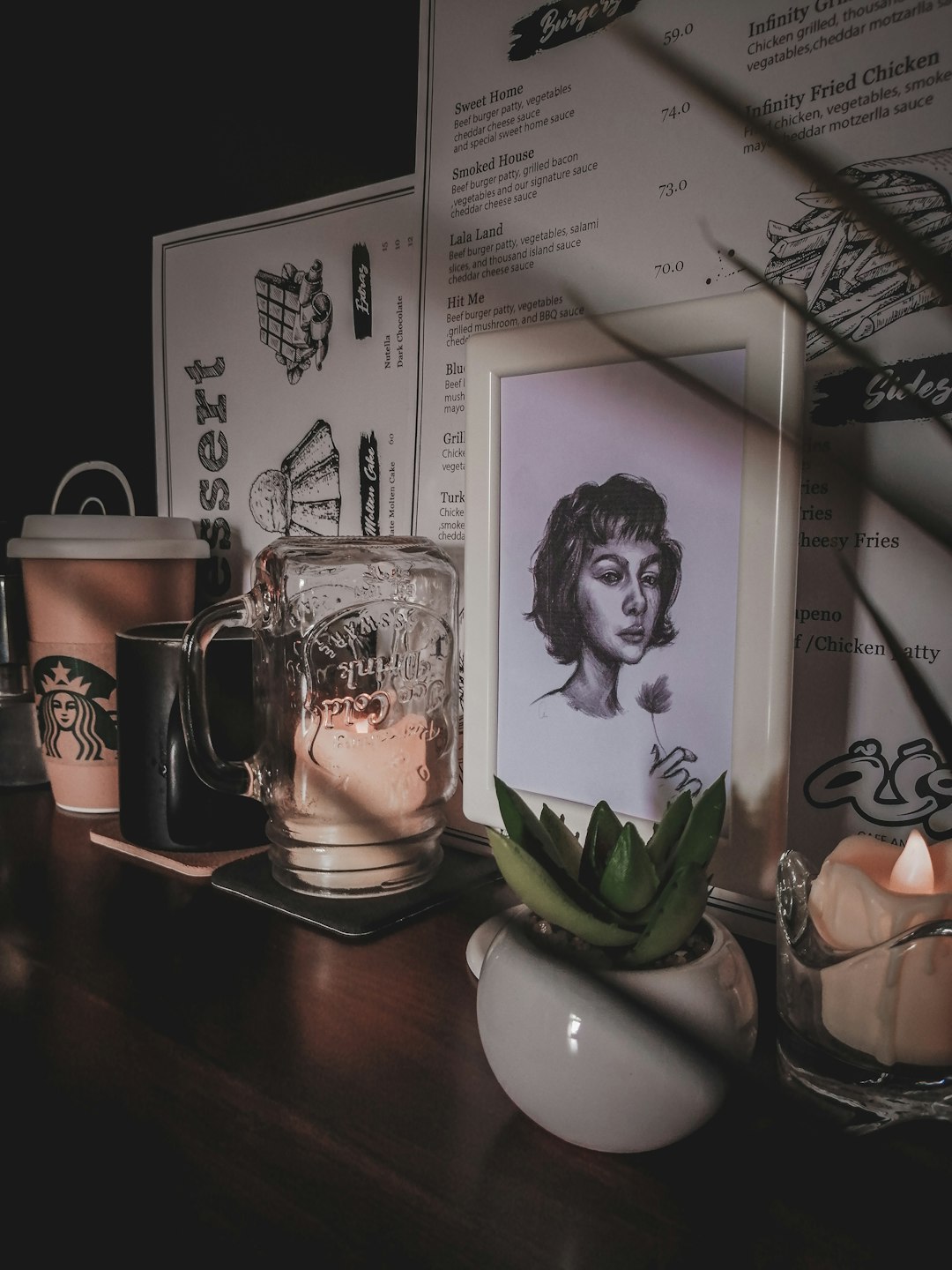 charcoal sketch of woman with frame near green succulent plant