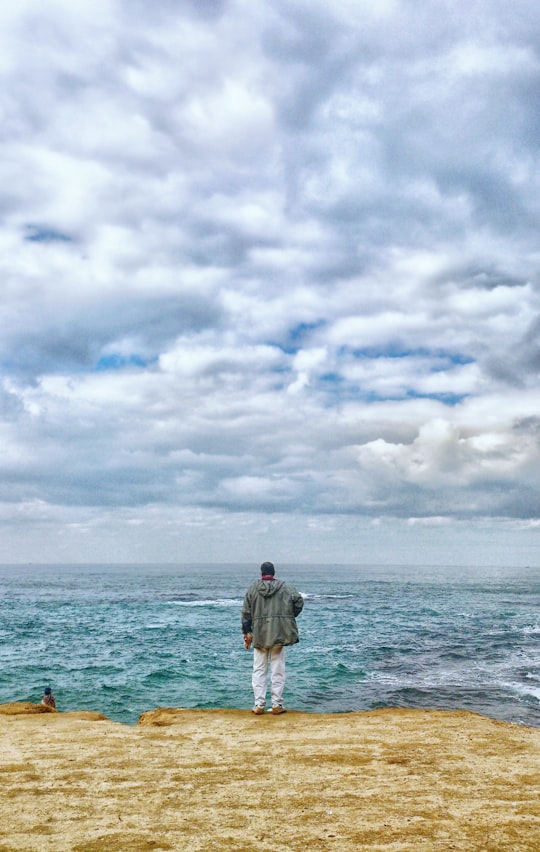 man standing in front of sea in Alexandria Egypt