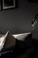 Softly lit living room with a muted beige abstract artwork displayed above a linen sofa.