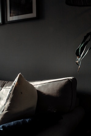 Softly lit living room with a muted beige abstract artwork displayed above a linen sofa.