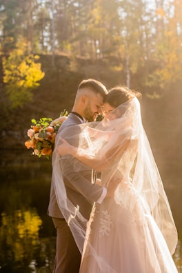 Bride and groom sharing a joyful embrace under soft golden sunset light.