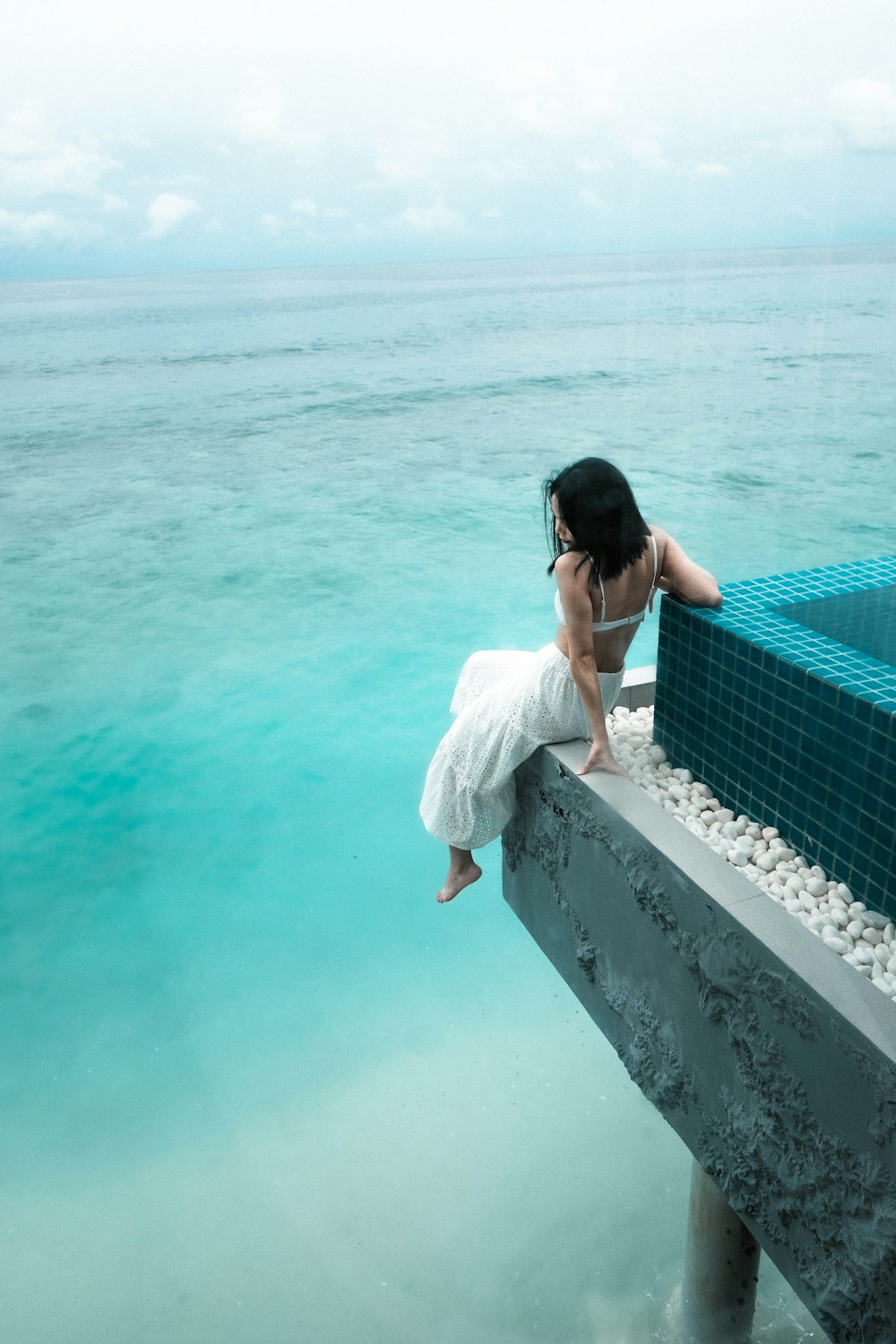 woman sits near shore