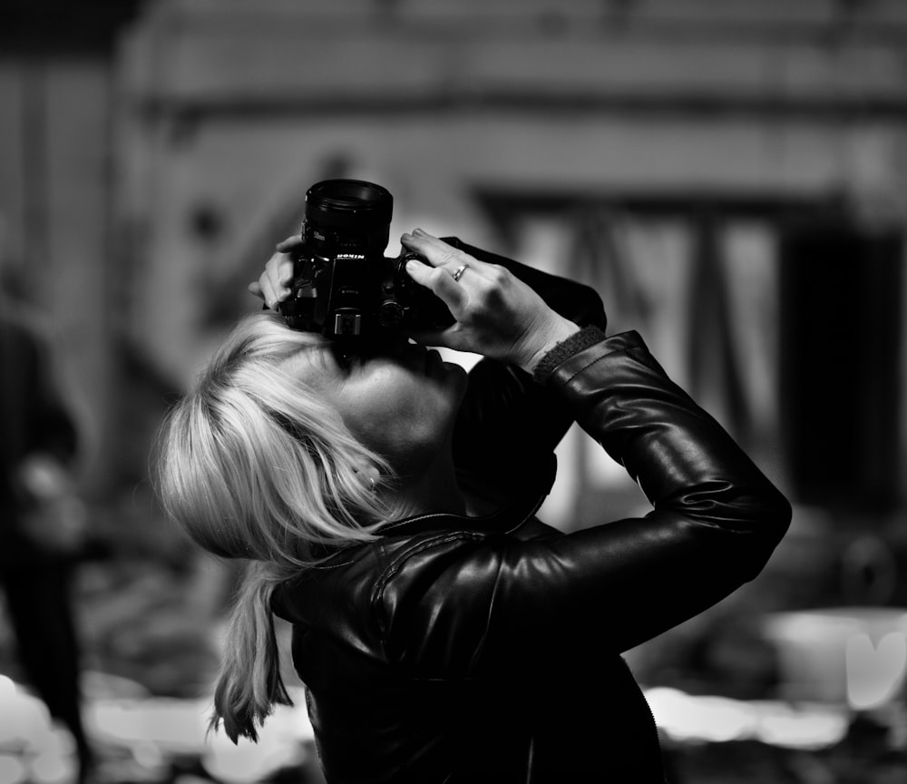 grayscale photo of woman using camera