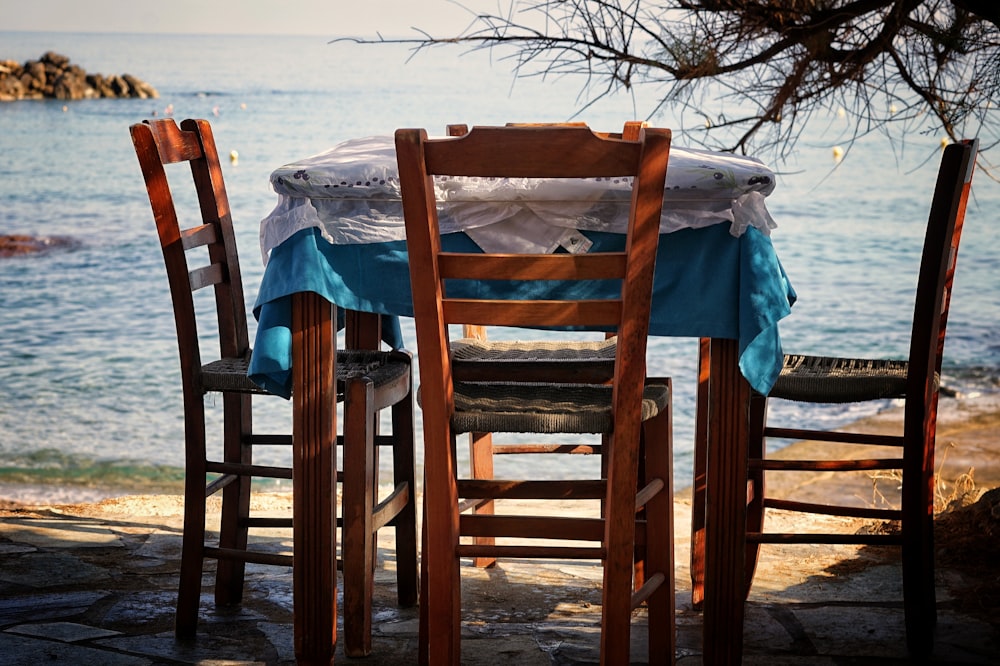 chairs and table near body of water