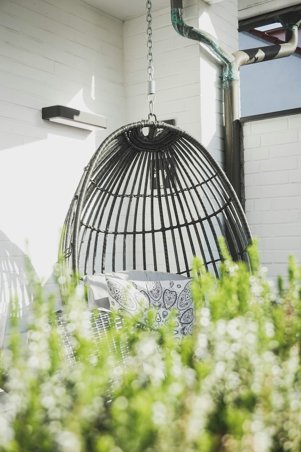 black rattan hanging chair near wall