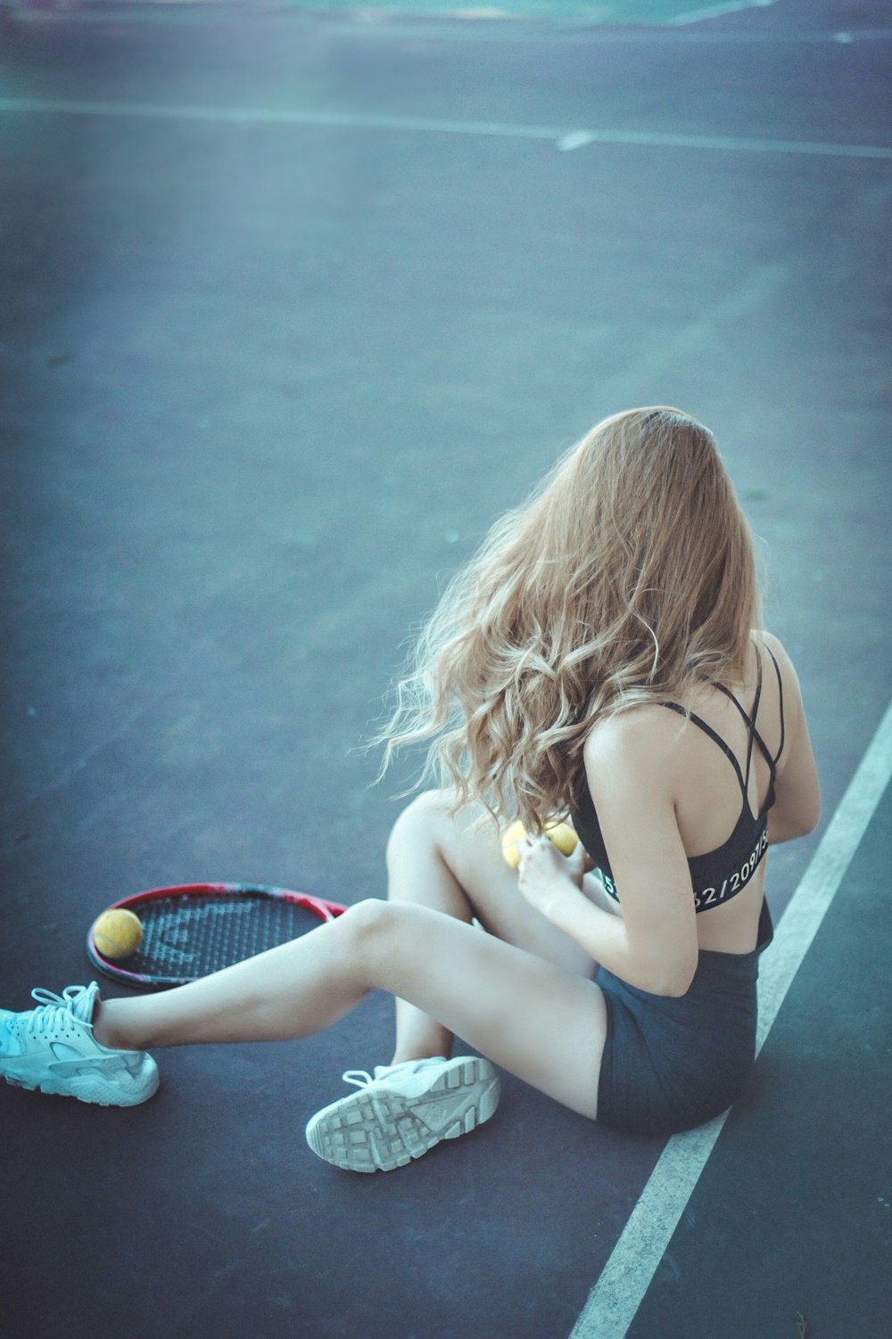 Frau sitzt in der Nähe von Badmintonschläger