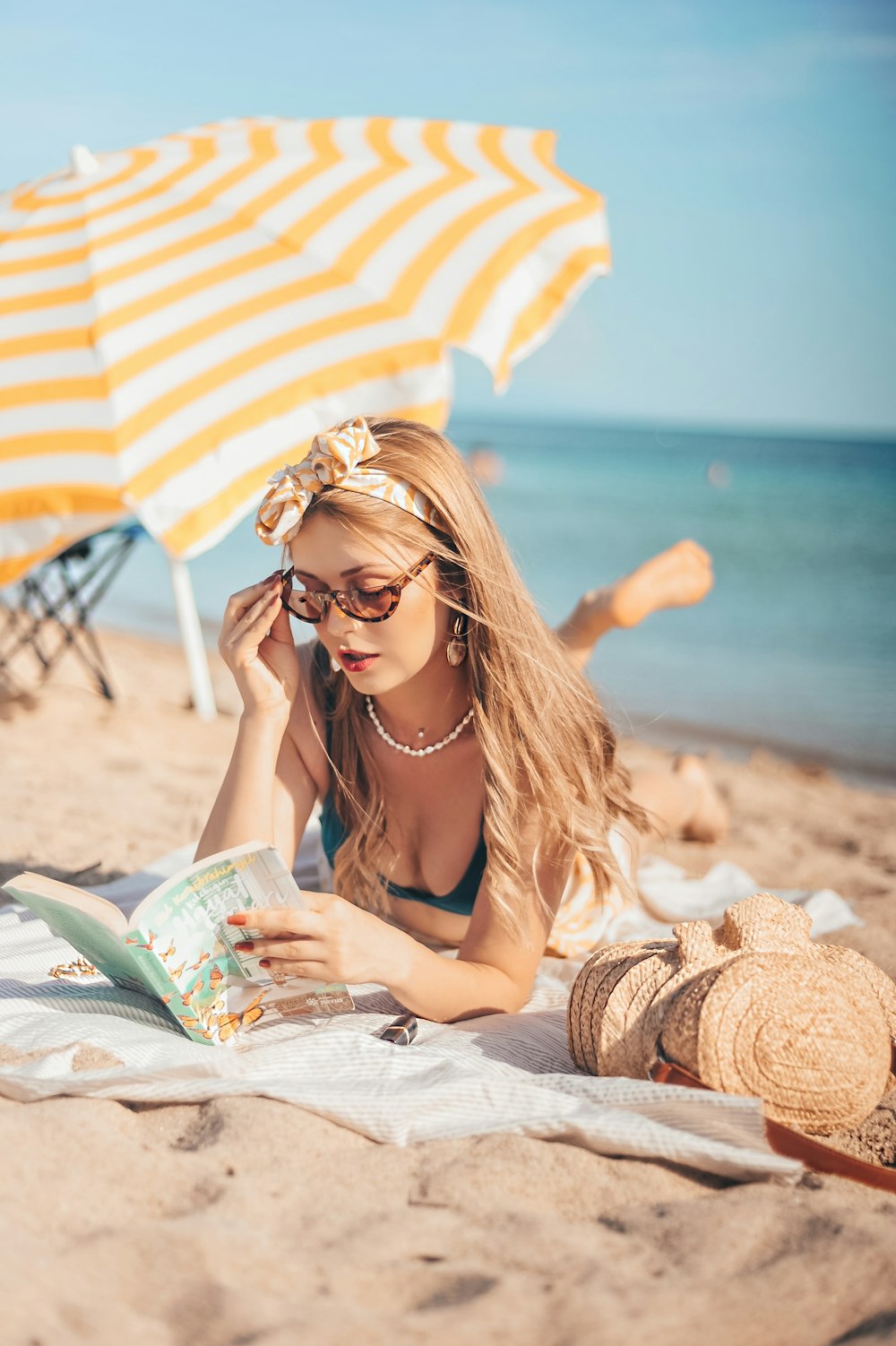 woman reads book near shore