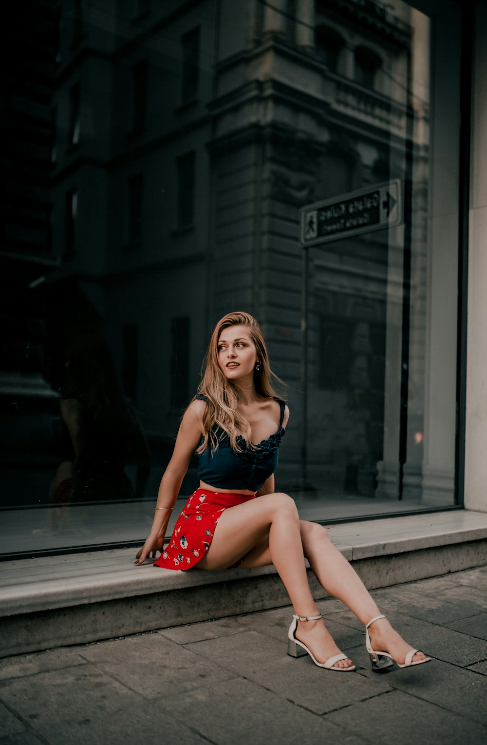 woman wearing black spaghetti strap top sitting while glancing her right side