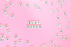 Scrabble pieces on pink surface