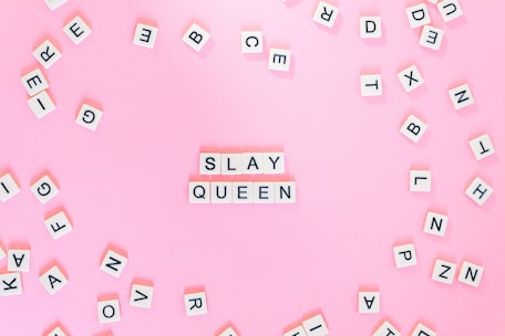 Scrabble pieces on pink surface