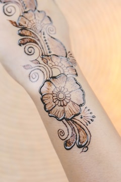 Intricate floral tattoo wrapping around a forearm.