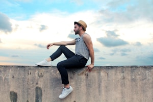 man sitting on concrete pavement