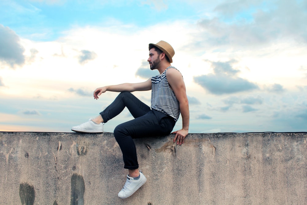 man sitting on concrete pavement