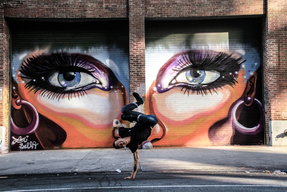 shallow focus photo of man doing hand stand