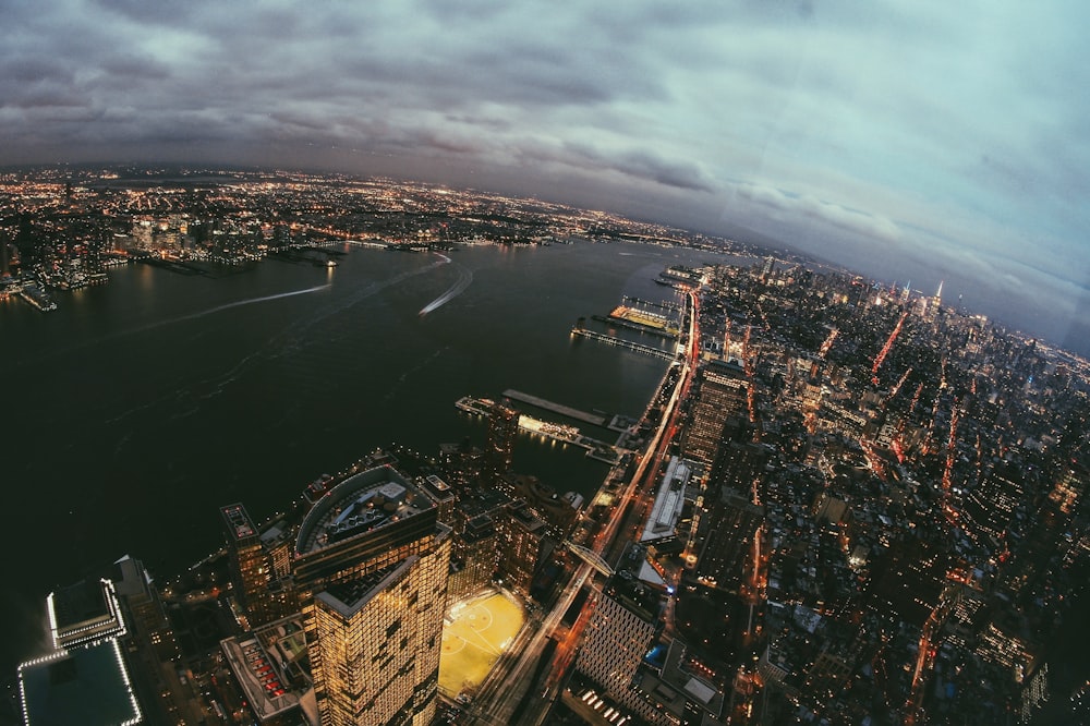 aerial photography of buildings beside calm water at night