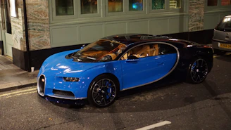 A sleek navy blue sports car parked under soft lighting, highlighting its curves.