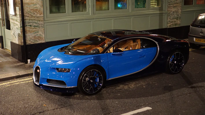 A sleek navy blue sports car parked under soft lighting, highlighting its curves.