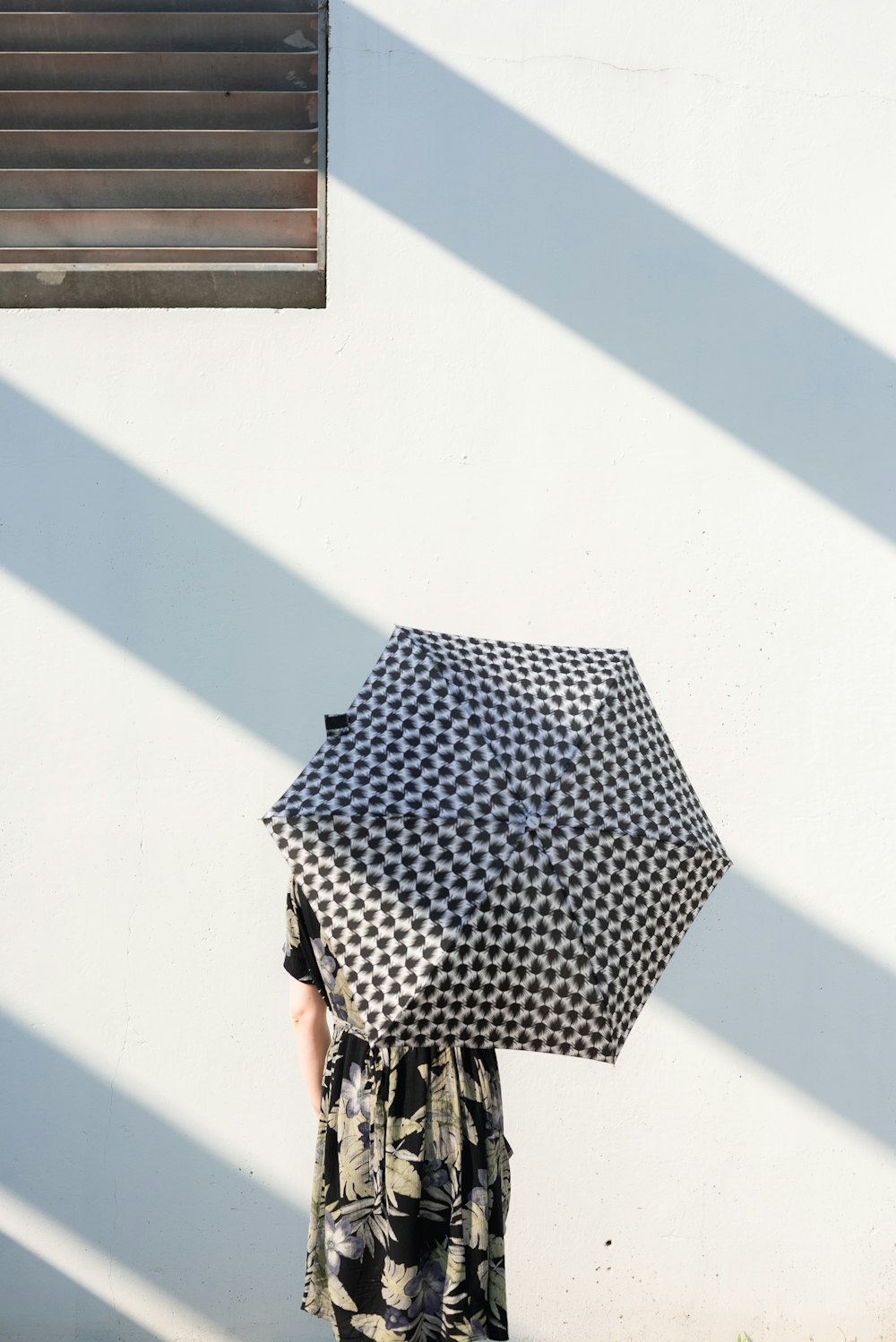 person holding black and white umbrella close-up photography