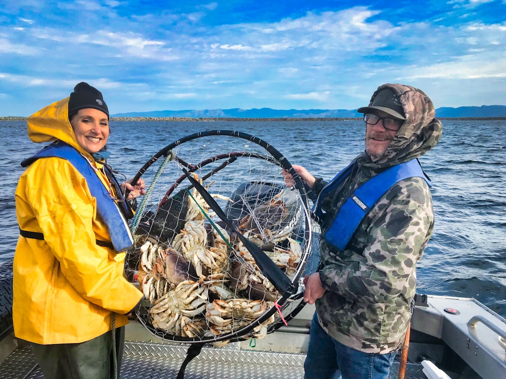 man and woman holding crab cage