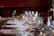A beautifully set wedding table featuring sparkling glassware and polished silverware under soft lighting.