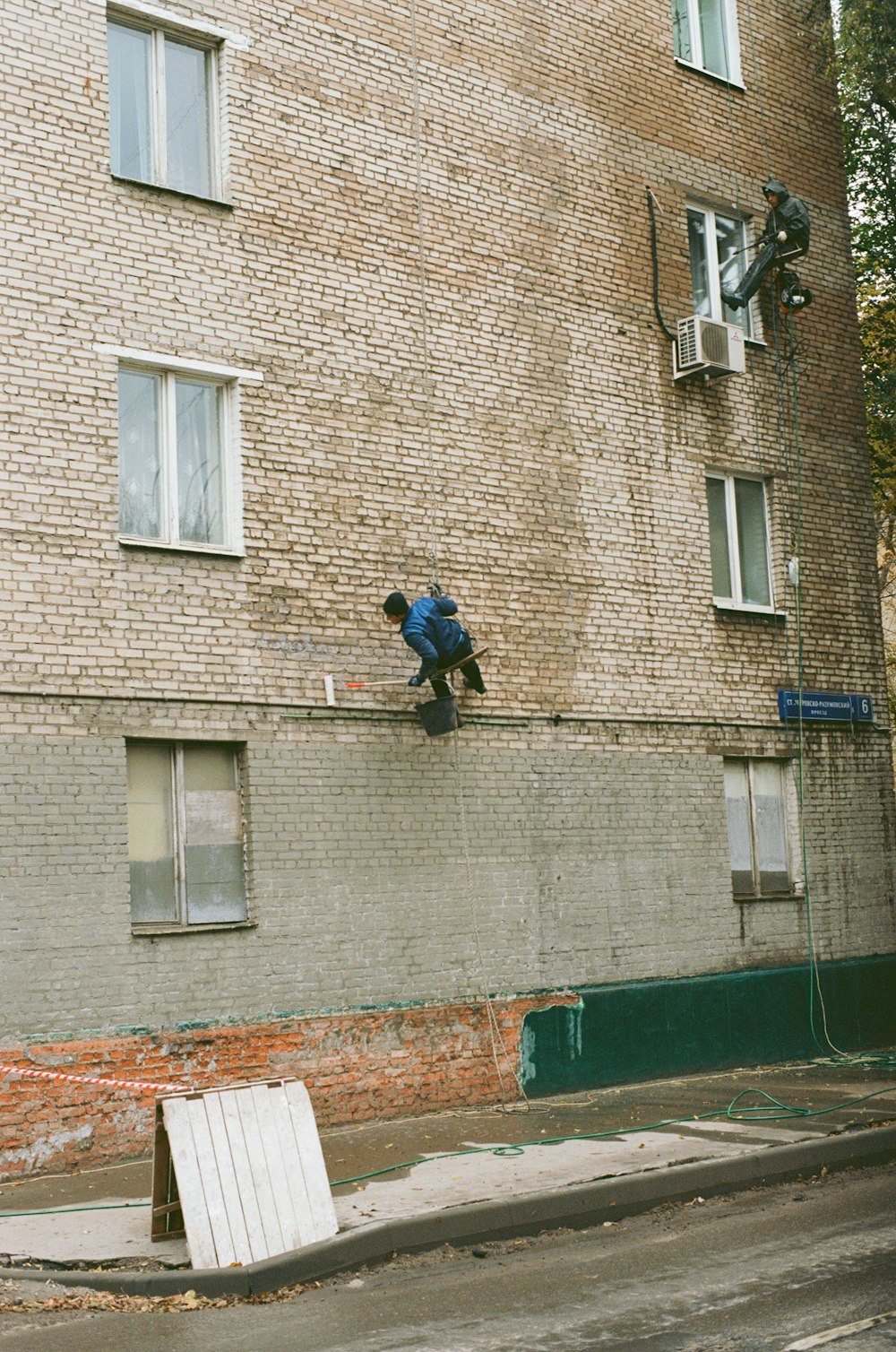 men by wall of building during daytime