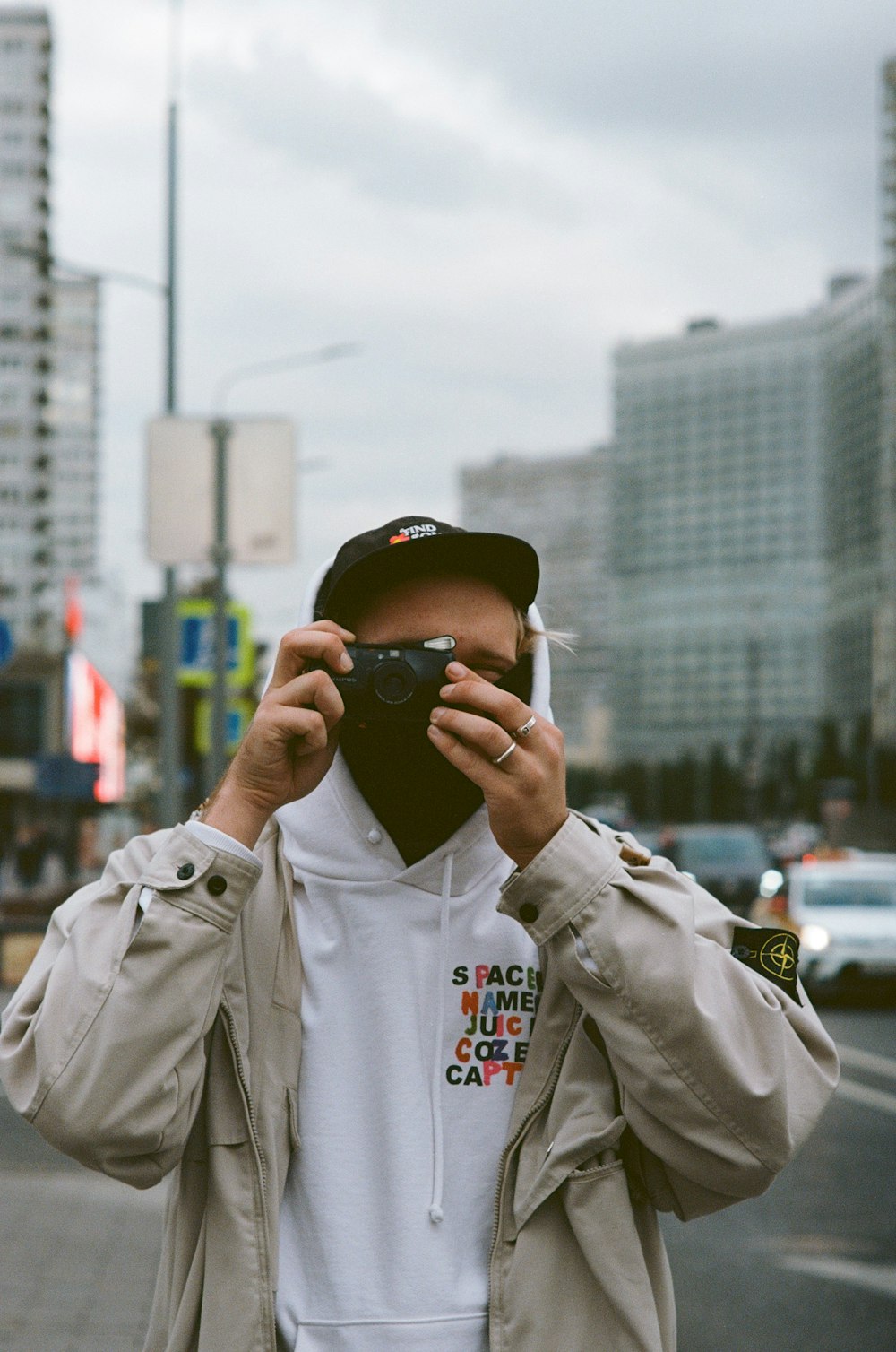 selective focus photography of man using camera by roadside