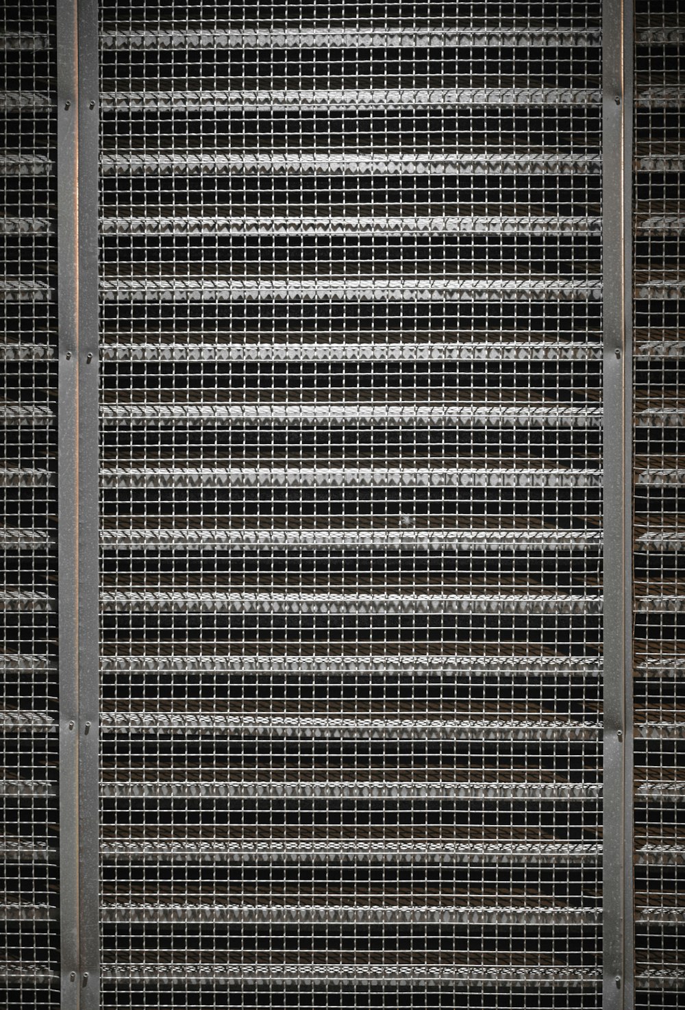 a black and white photo of a metal fence