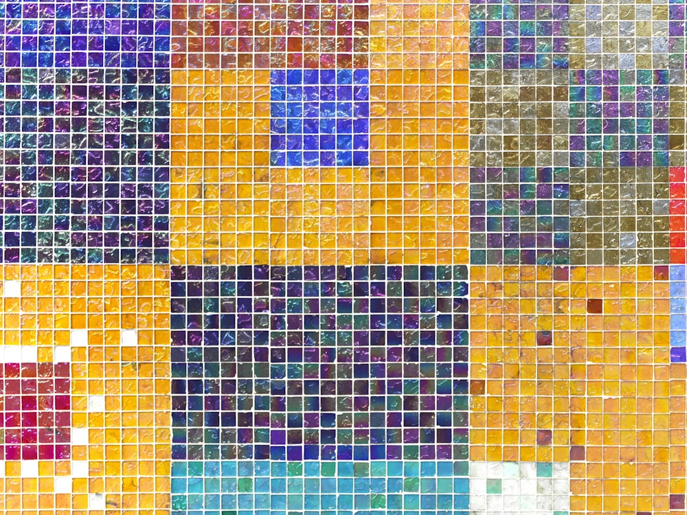 a multicolored tiled wall with a blue square in the middle