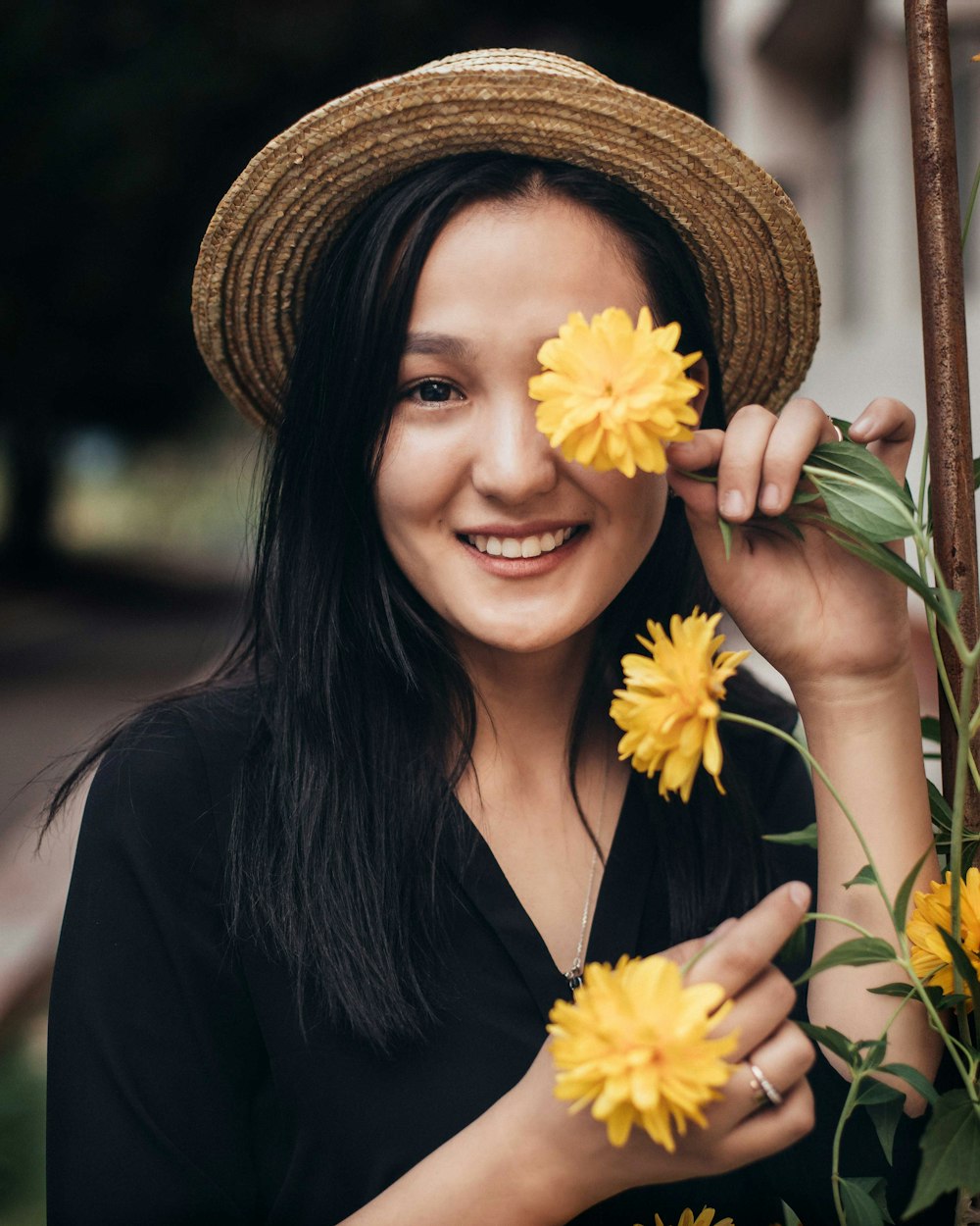 woman holding flower while covering her eye