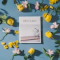 Proverbs book beside white and pink flowers