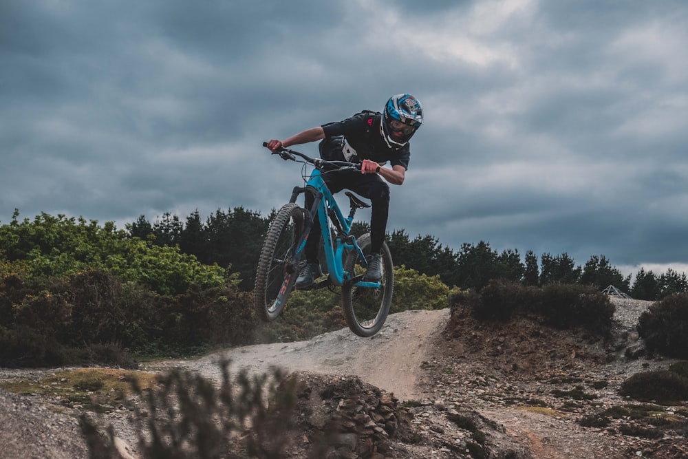 man wearing black pants riding hardtail mountain bike