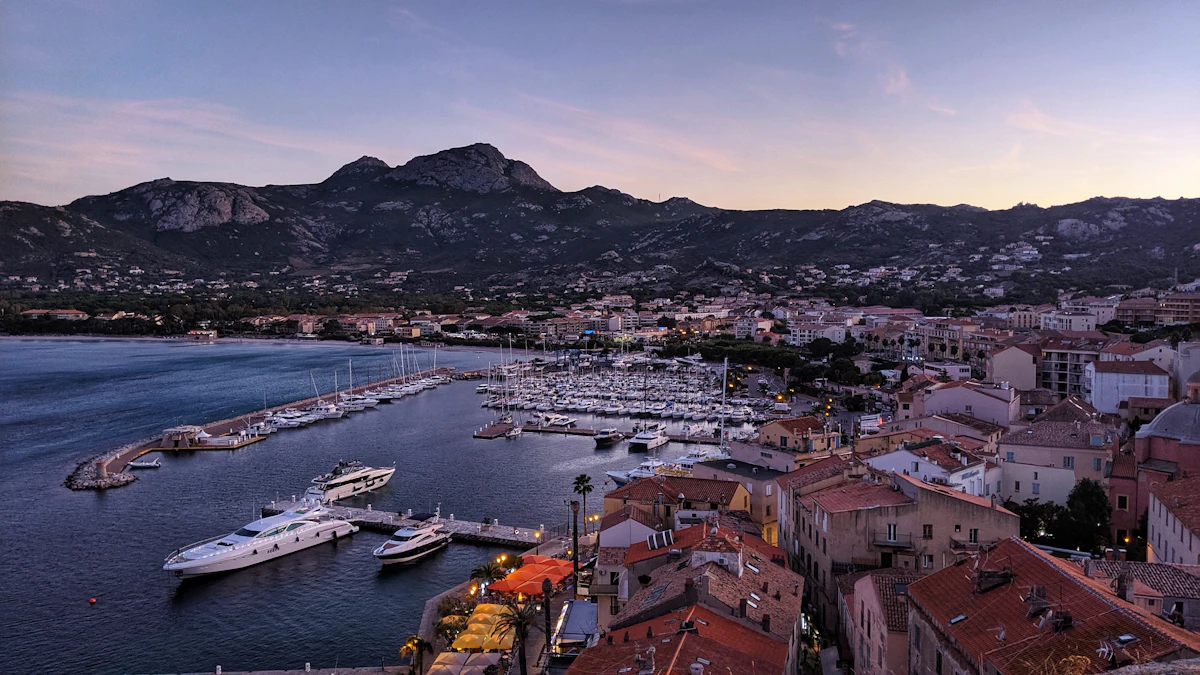 Le port de Calvi et sa baie au crépuscule, les montagnes en toile de fond